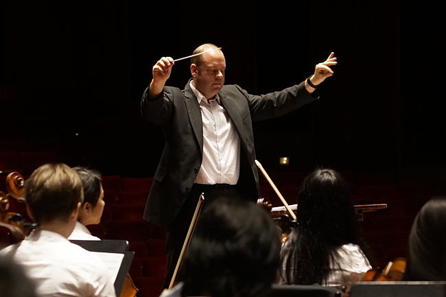 Shen Yun Performing Arts conductor Leif Erikson Sundstrup giving the cutoff during rehearsal at Hous