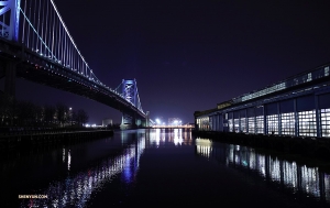 A night view of the Benjamin Franklin Bridge suspended over the Delaware River.
