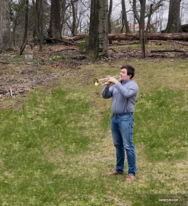 Trumpet player Eric Robins in his backyard. He says he’s playing nature’s melody.