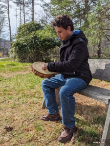 Percussionist Brian Marple took his tambourine out for some fresh air in his yard. Yes, the trees and bench make his backyard look like a park. 